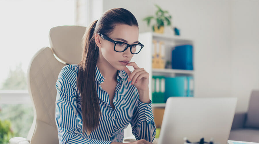 Smartly dressed woman staring intently at her laptop