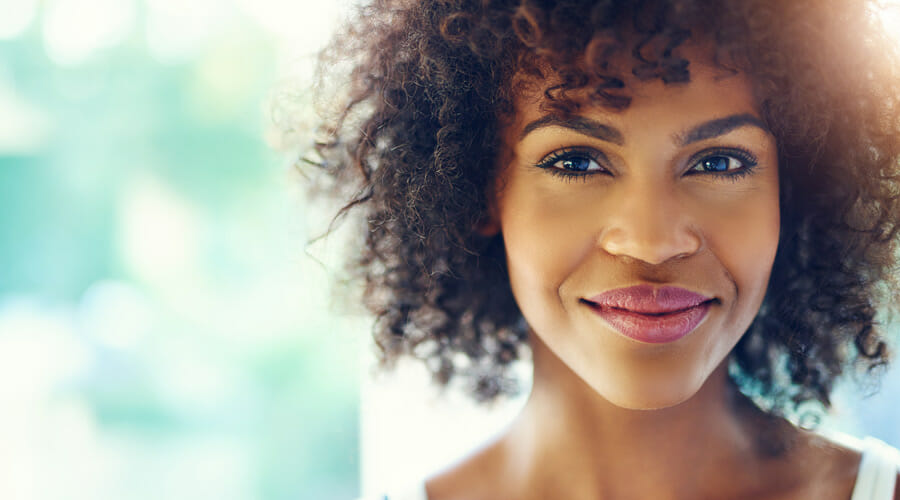 a woman with curly hair staring at the camera and smiling