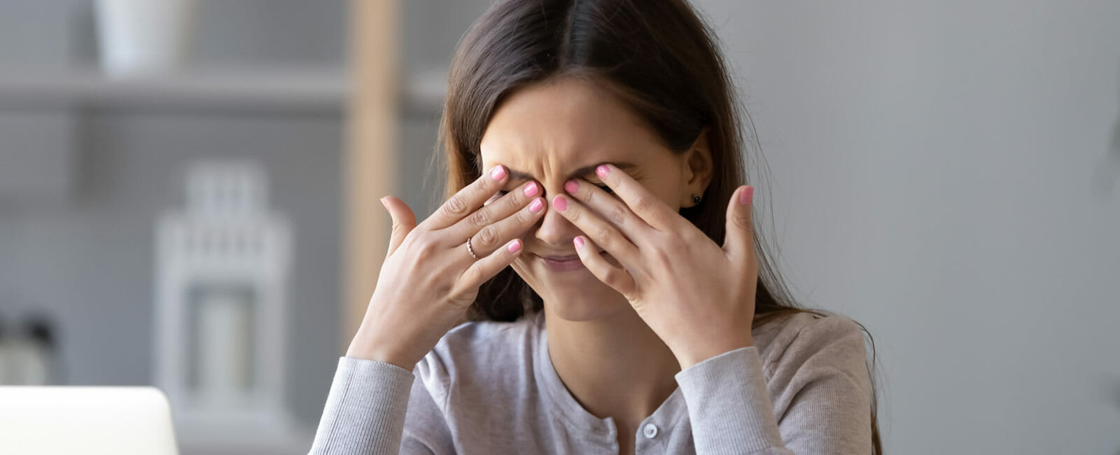 A young woman rubbing her eyes in discomfort
