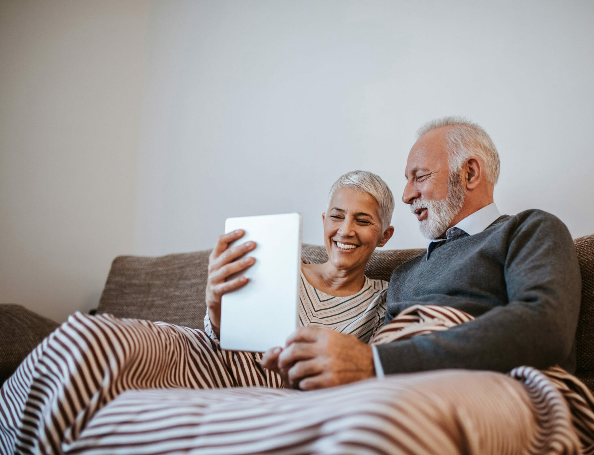 An elderly couple using facetime on a tablet